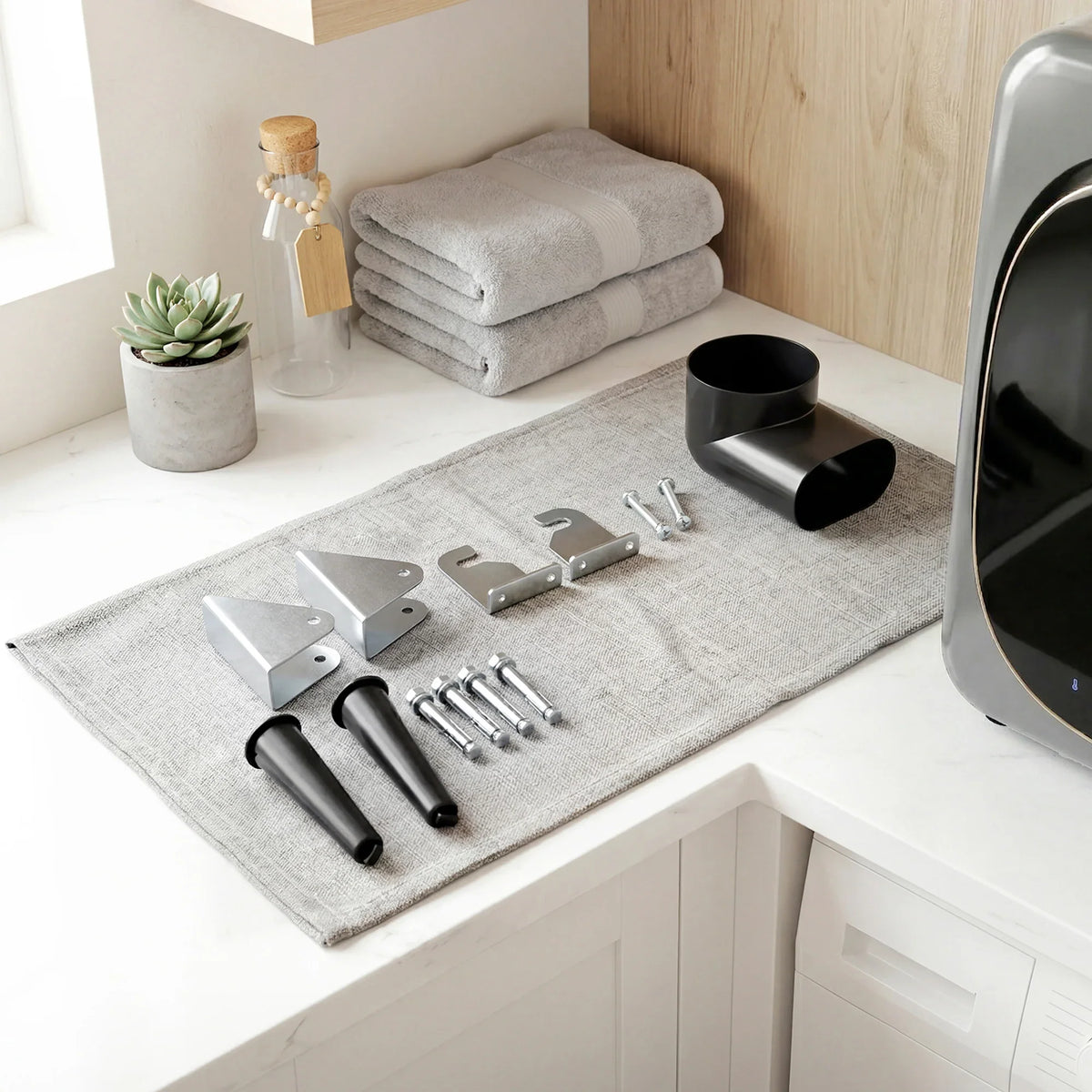 Compact vented tumble dryer with included installation tools and accessories on mat