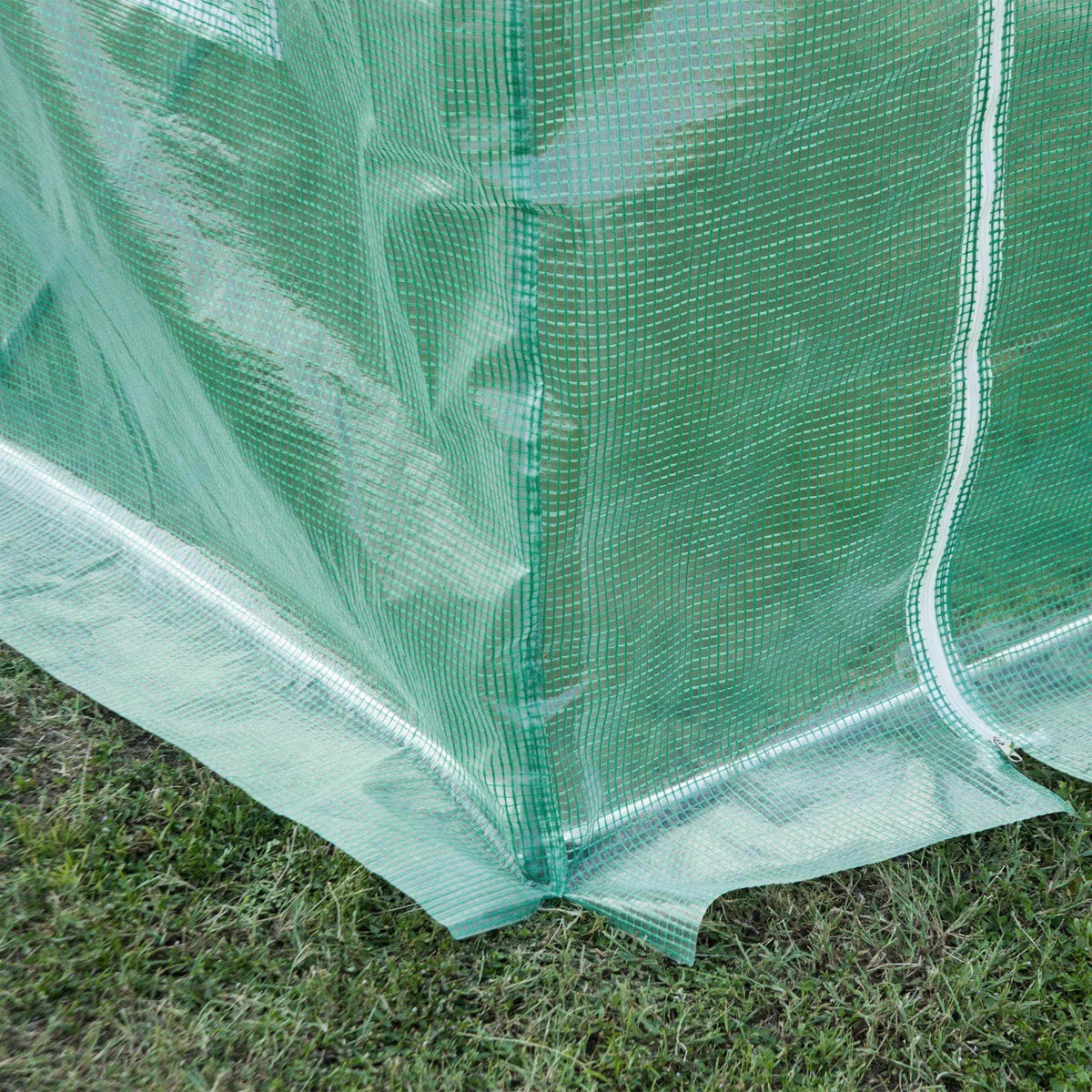 Close-up of green PE greenhouse cover mesh with stitched seams and bottom hem
