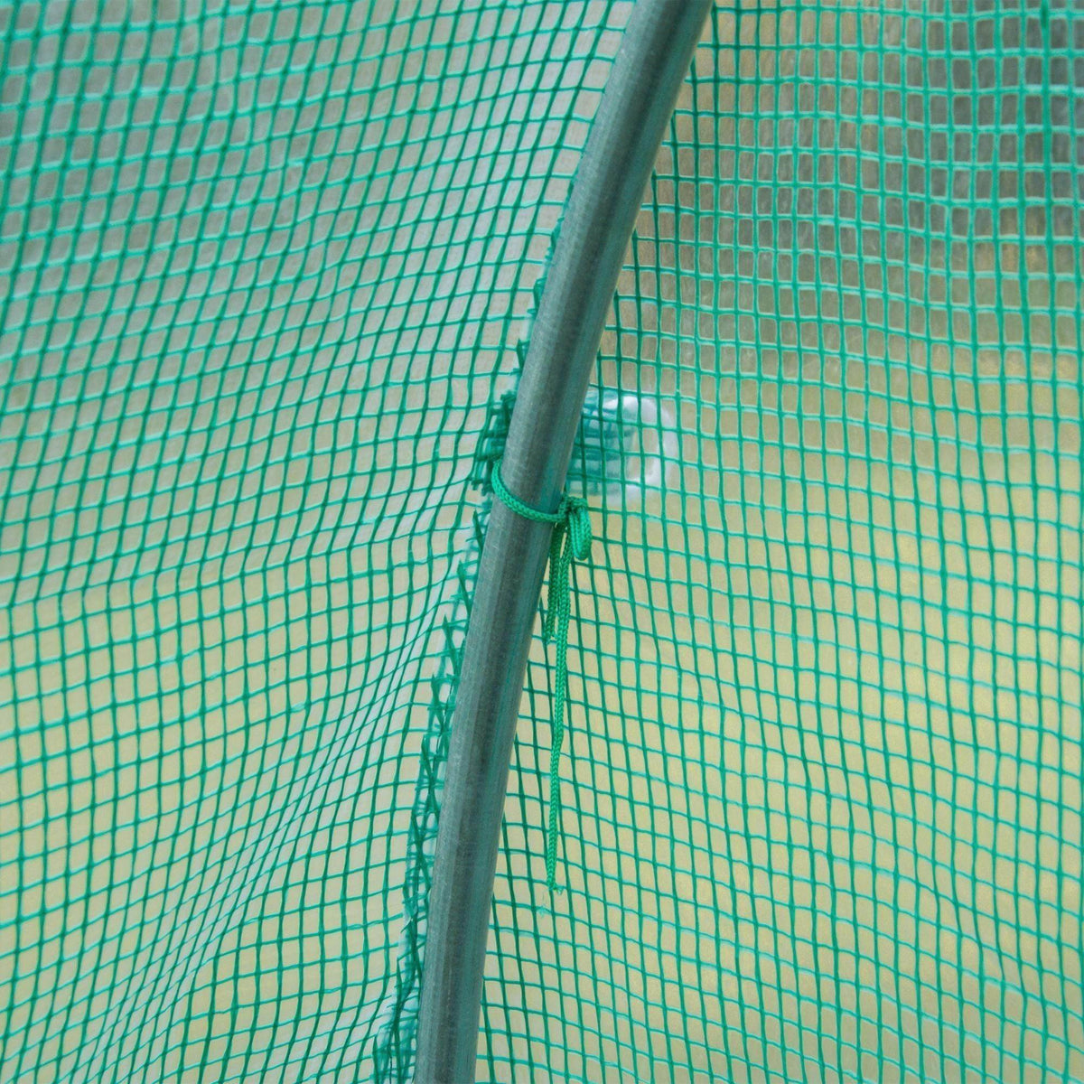 Close-up of green PE greenhouse cover corner pole sleeve and fine grid mesh
