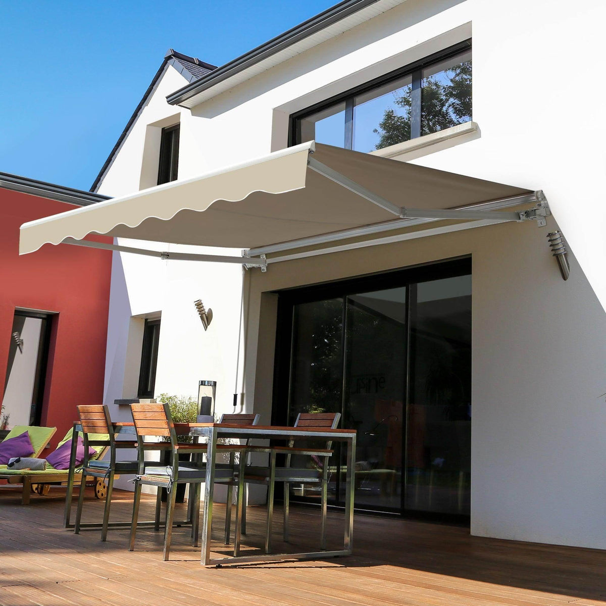 Manual retractable awning with beige fabric and white frame above patio windows