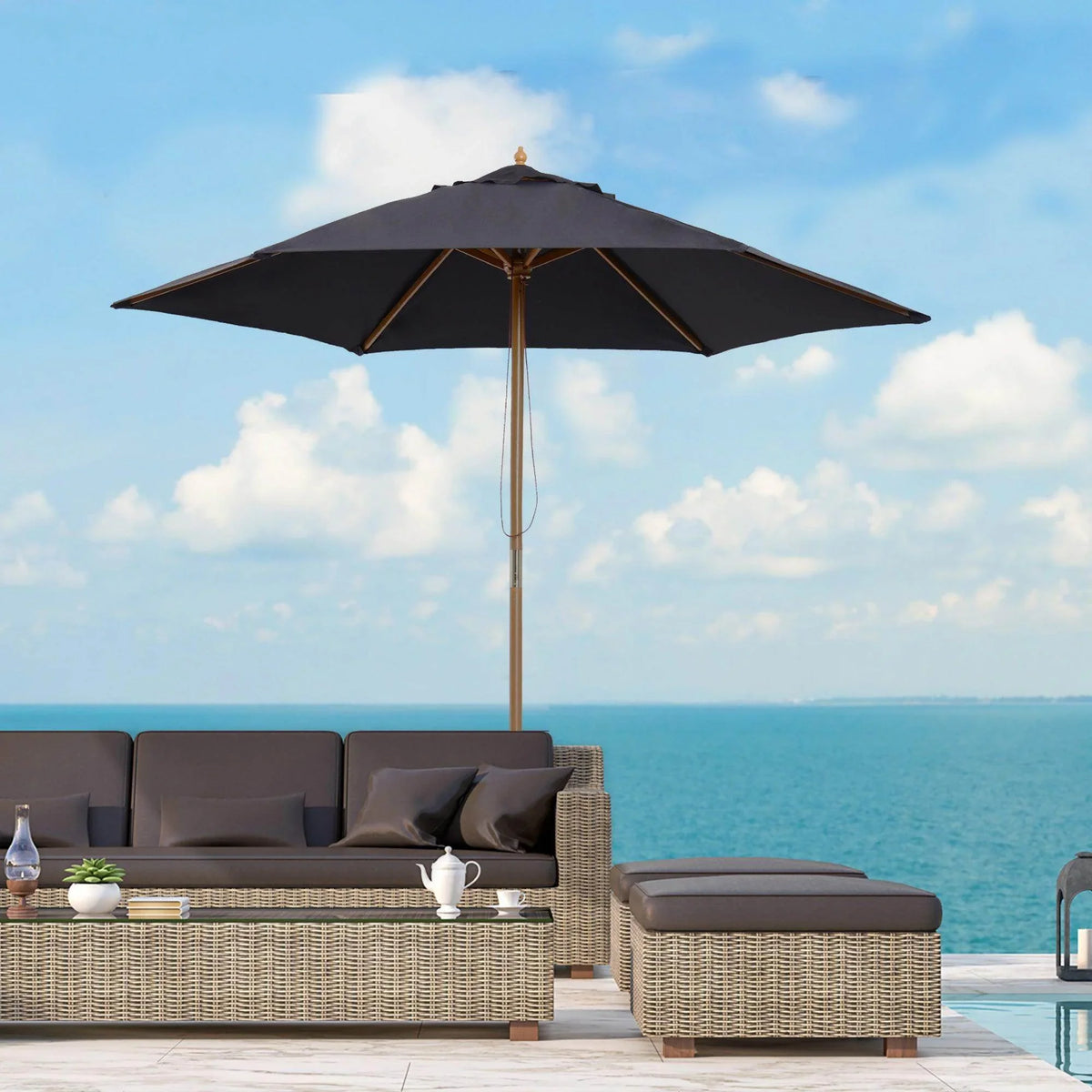 Black outdoor patio umbrella shading wicker sofa set by ocean, perfect for garden or poolside relaxation