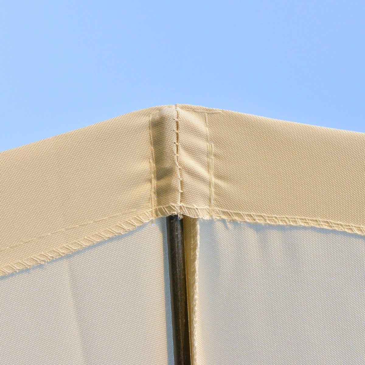Off-white umbrella canopy seam detail with fabric edge and metal support pole