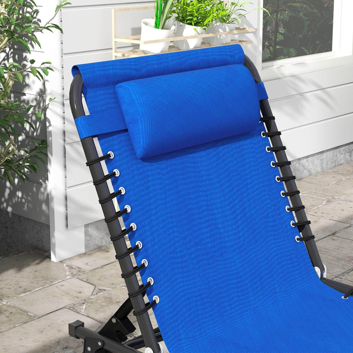 Close-up of a blue folding sun lounger with padded headrest and black corded frame