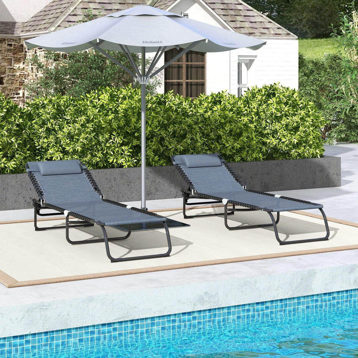 Two grey folding sun loungers with adjustable backrests on black frames near a pool