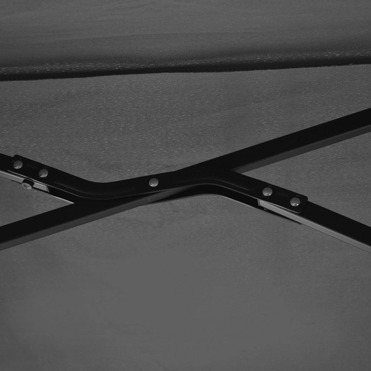 Black half parasol frame hub and joint hardware beneath the canopy