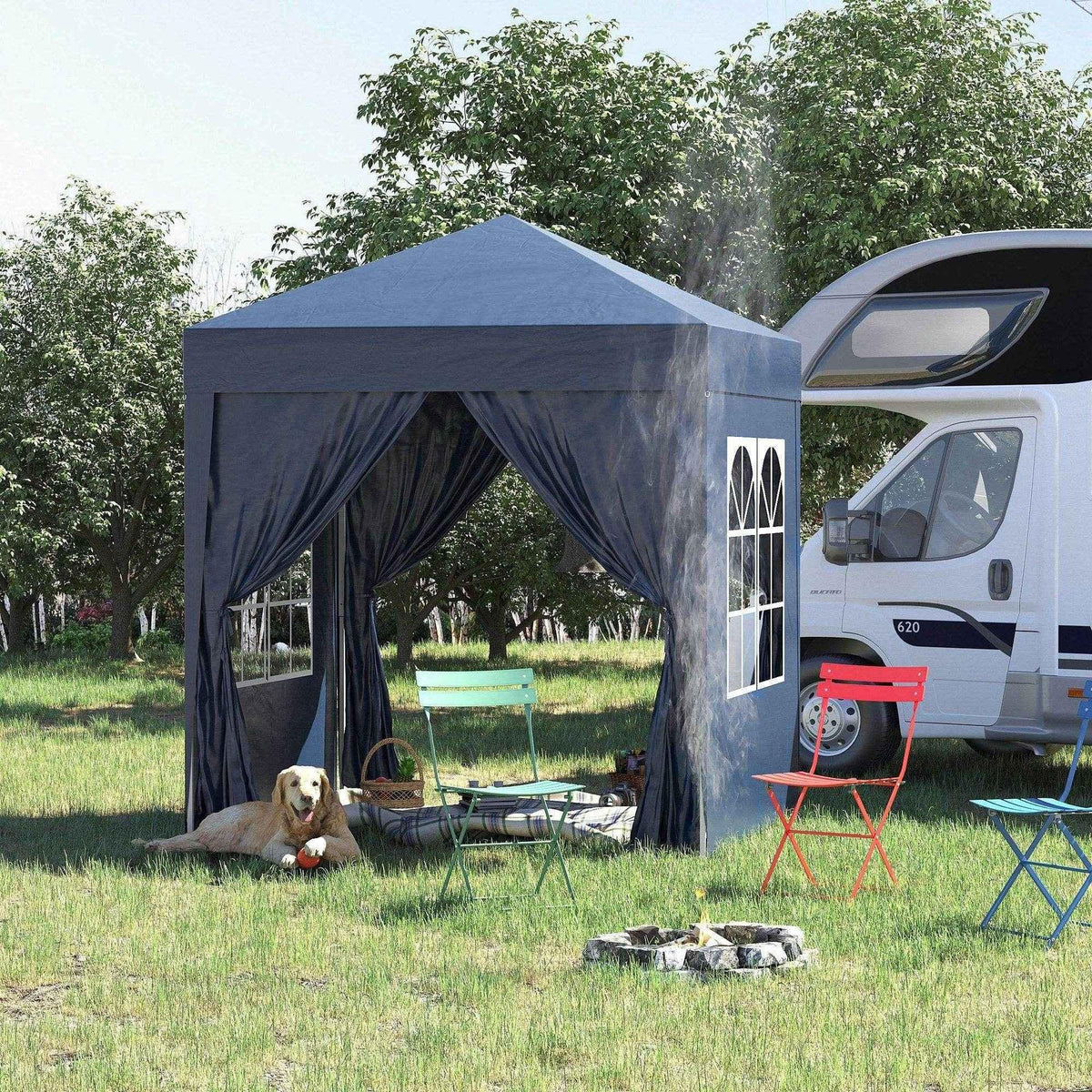 Gray pop-up gazebo with curtains, outdoor chairs, and dog beside RV in grassy yard