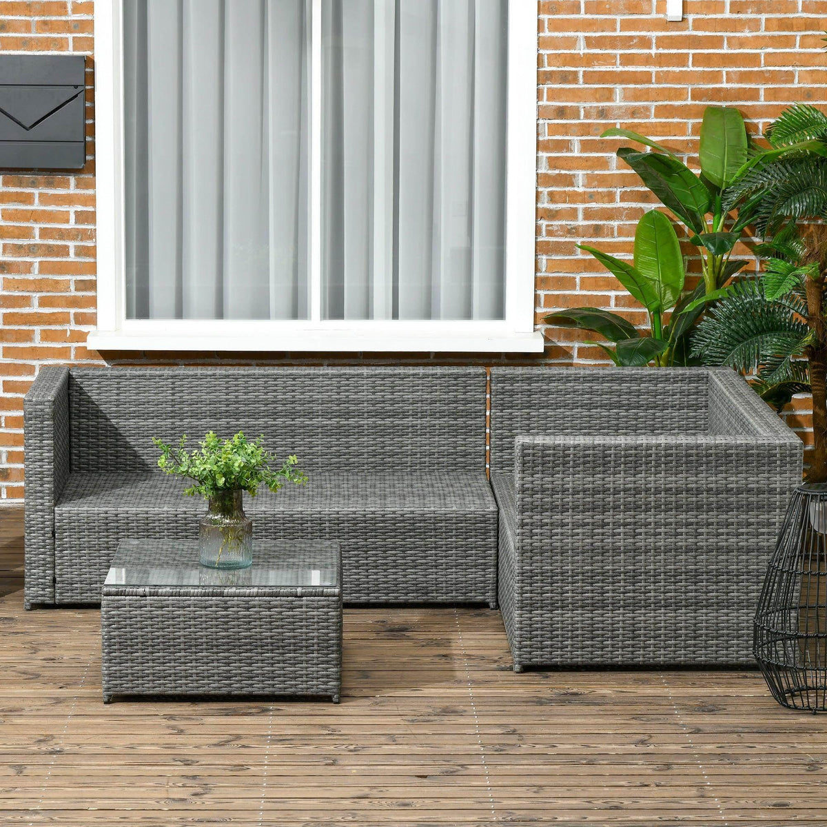 Grey rattan corner sofa set with cushions and glass-top coffee table