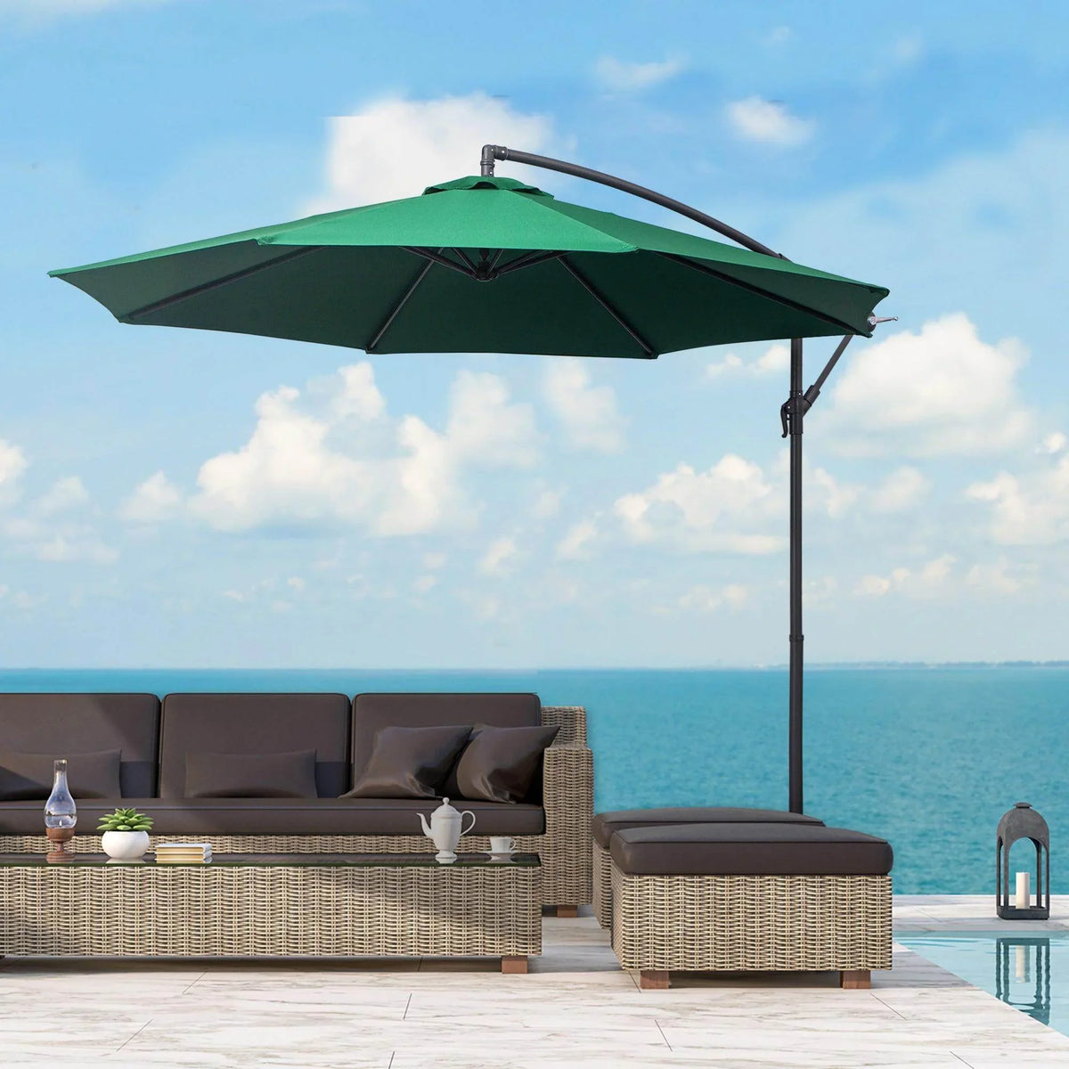 Green cantilever patio umbrella shading wicker outdoor sofa by ocean, perfect for garden or poolside relaxation.