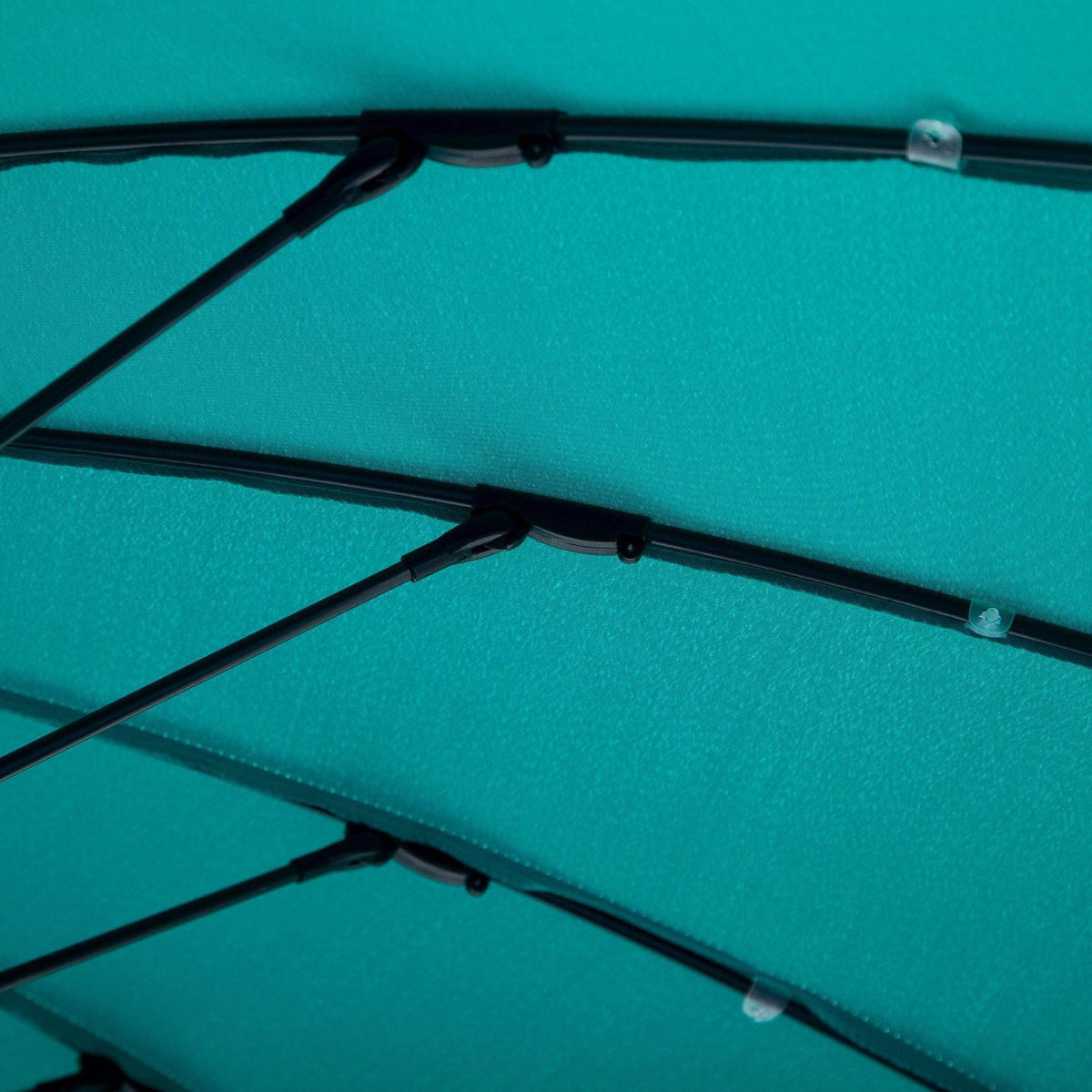 Turquoise umbrella canopy close-up showing rib bars and fabric panel seams