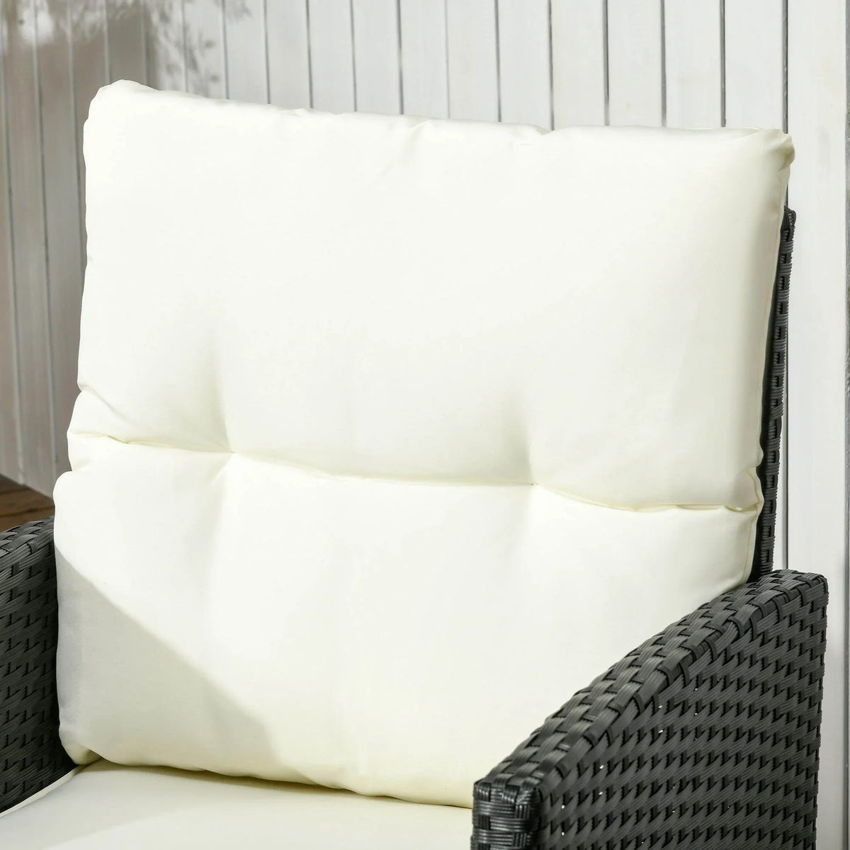 Cream cushion on black rattan lounge chair backrest