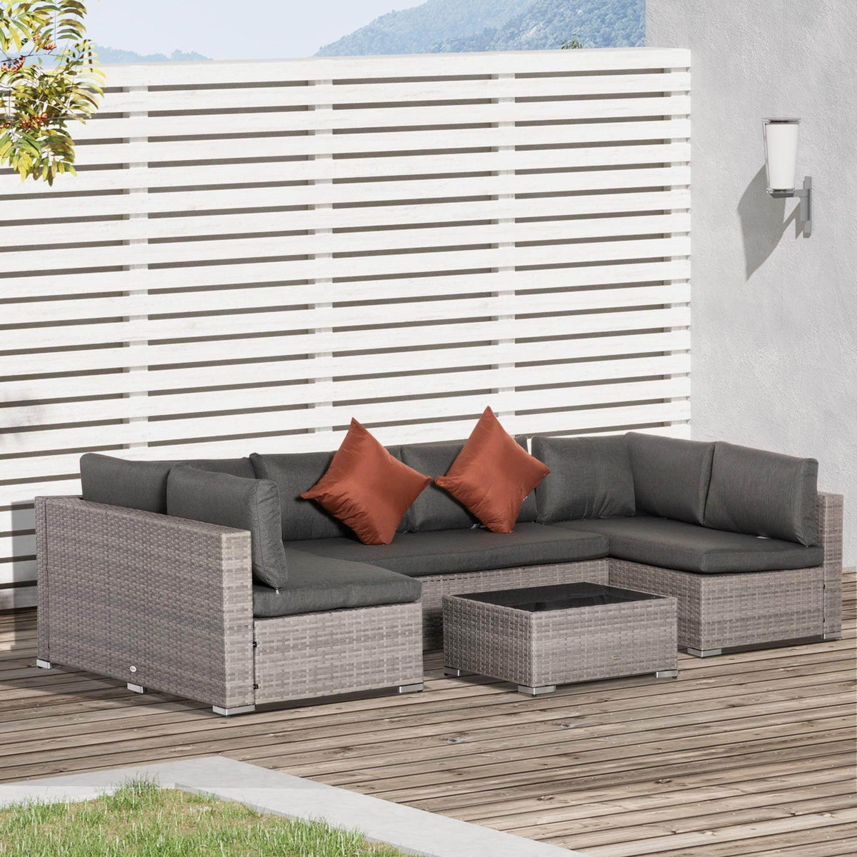 Outdoor gray rattan sofa set with dark cushions and terracotta throw pillows