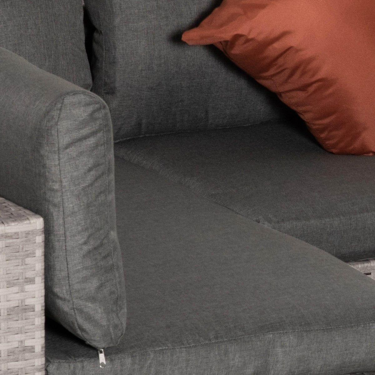 Gray outdoor sofa cushion and stitched armrest with textured rattan side panel