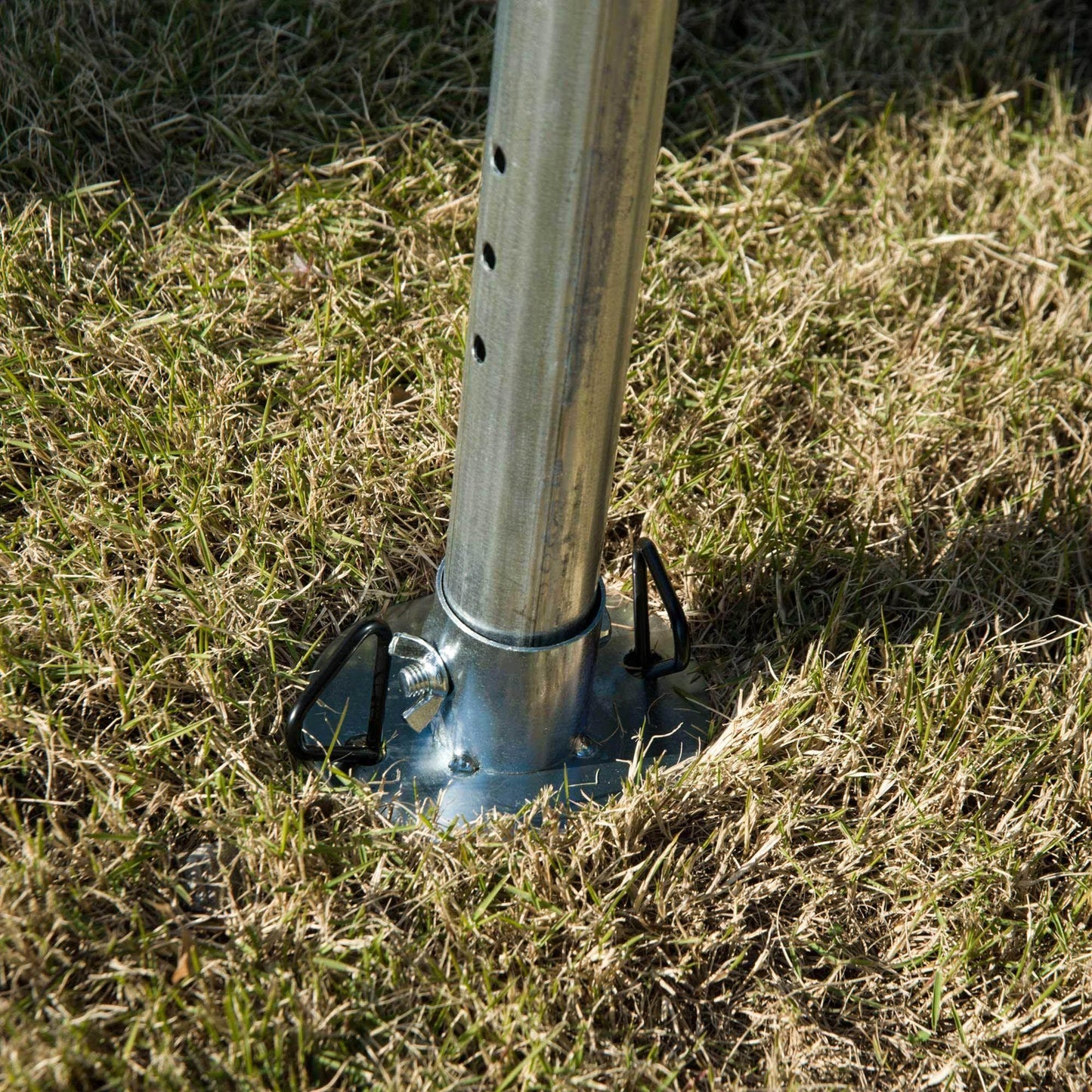 Heavy-duty steel frame garden gazebo leg securely anchored in grass with metal base plate and wing nut bolts