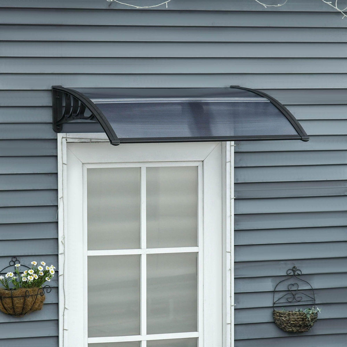 Black door canopy awning with curved frame and translucent ribbed panel installed above door