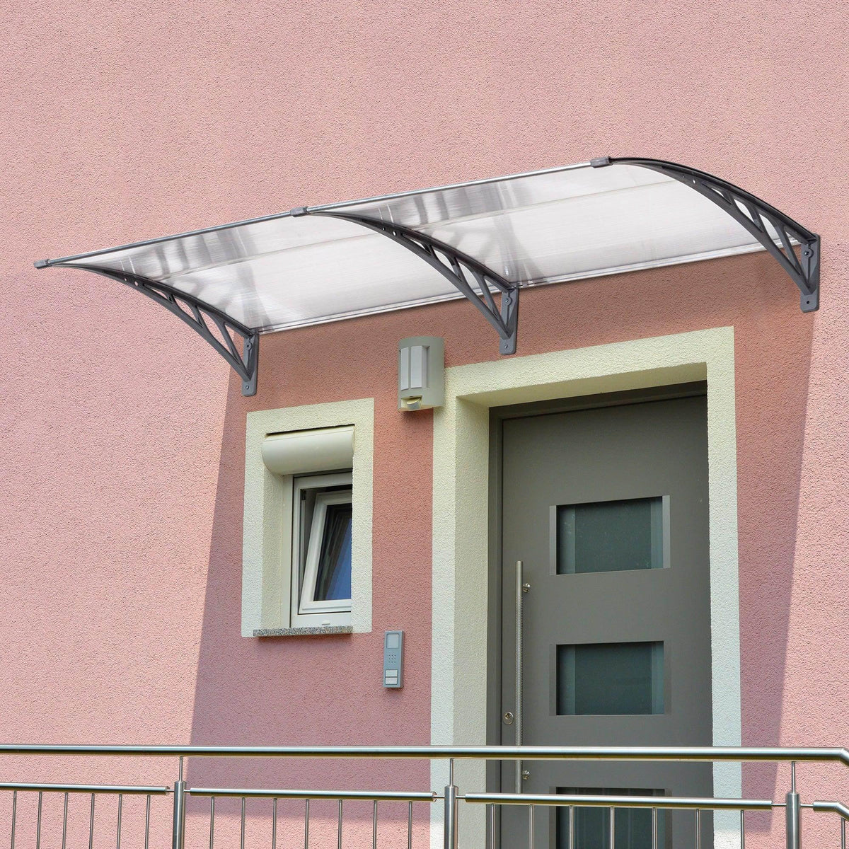 Clear door canopy awning installed over entry with dark gray frame and transparent roof