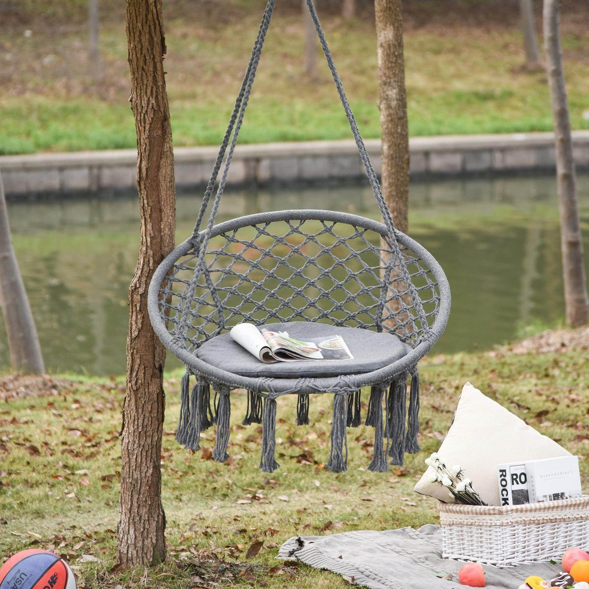 Grey round macrame swing chair with woven net seat and hanging tassels