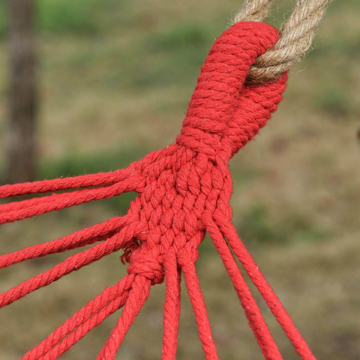 Close-up of red braided rope knots and hanging loops for hammock swing