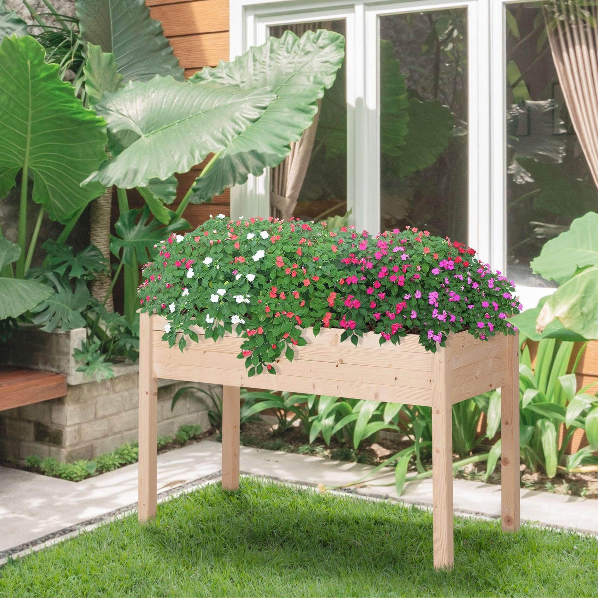 Elevated wooden planter with legs, holding dense row of colorful flowers outdoors