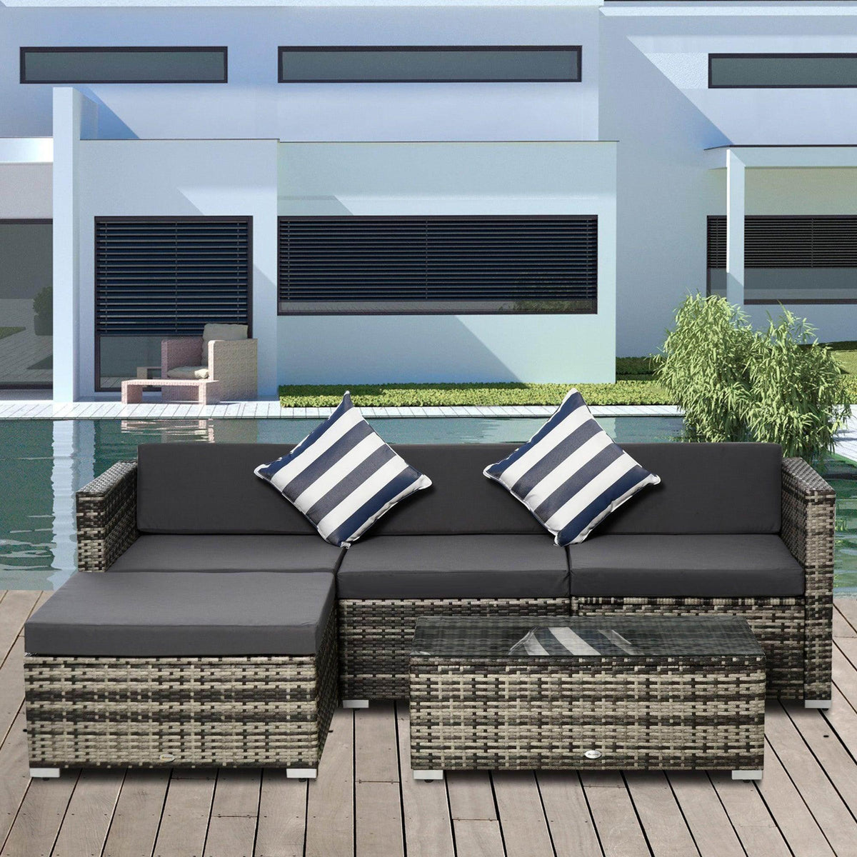 Outdoor rattan sofa set with dark seat cushions and two blue-and-white striped pillows