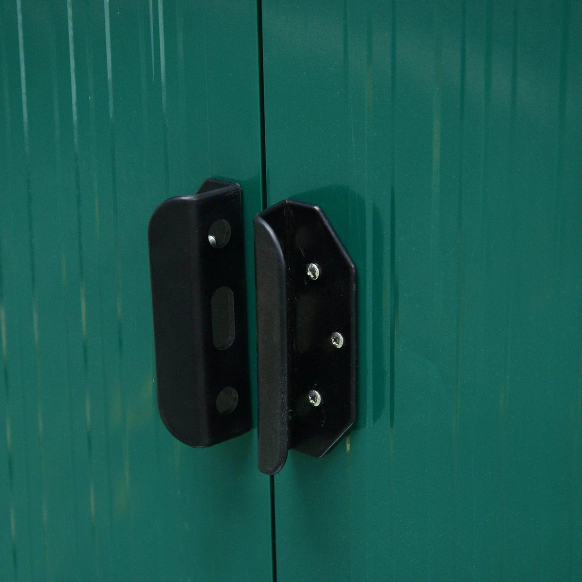 Black lock latch on green metal garden shed sliding door