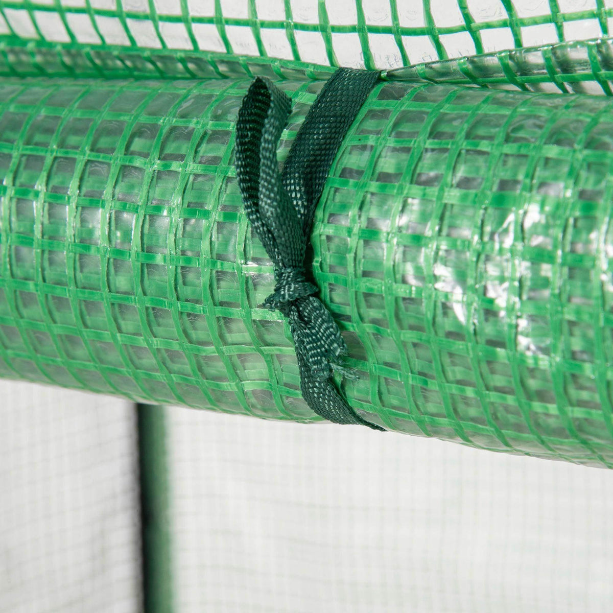 Green PE greenhouse cover roll-up edge with black drawstring cord close-up