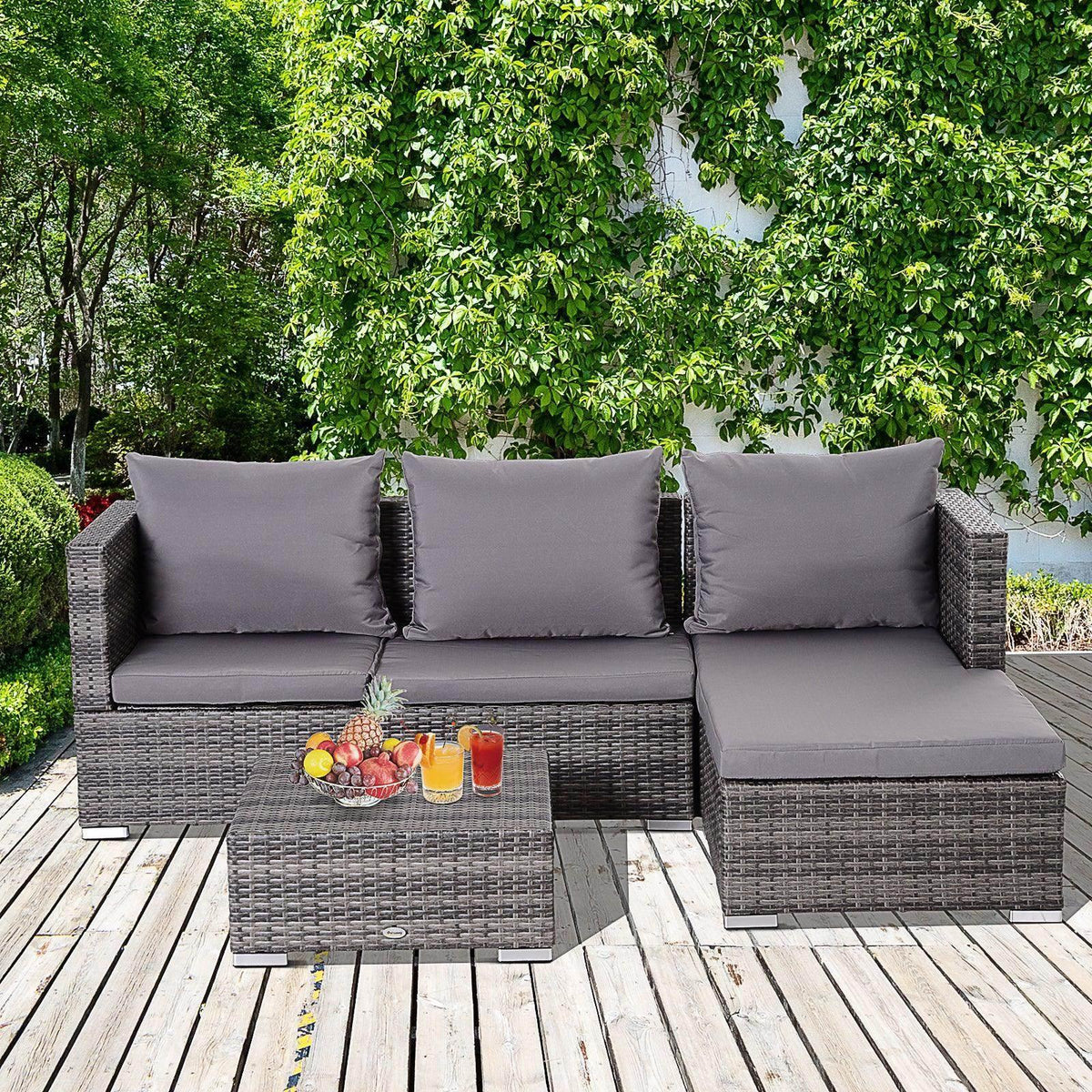 Grey rattan outdoor seating set with three-seat sofa, chaise lounge, and matching ottoman