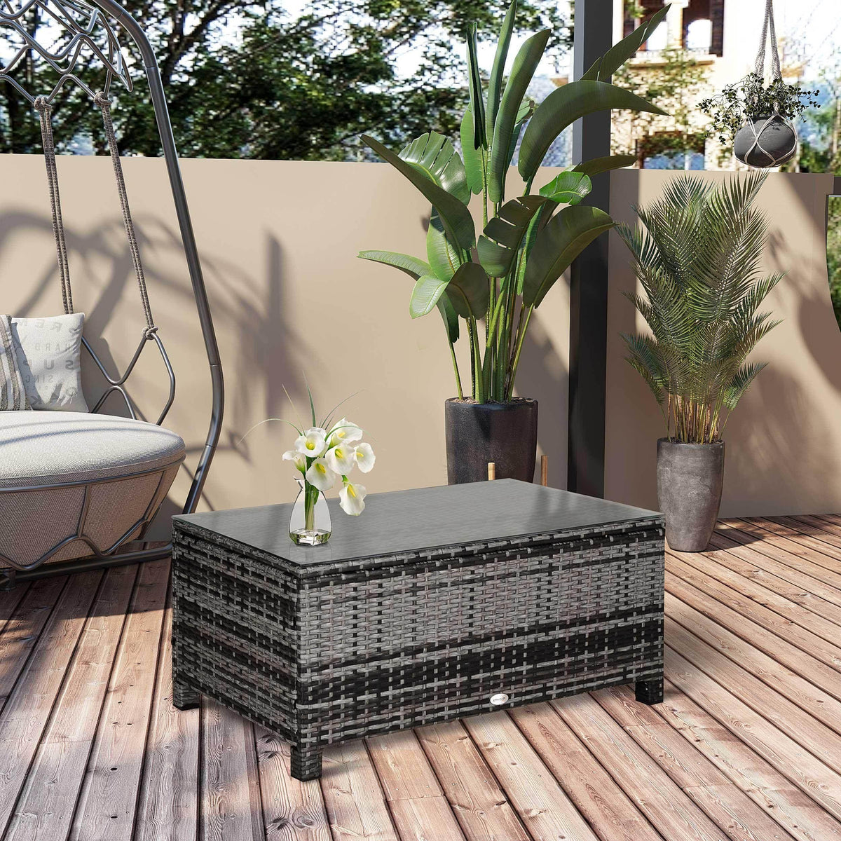 Grey rattan coffee table with clear glass top, framed with woven lattice.