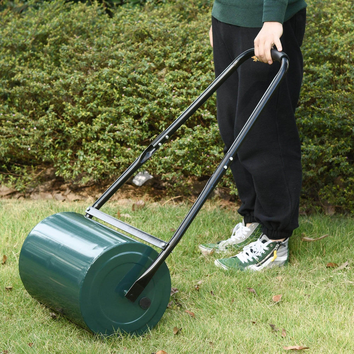 Green heavy-duty lawn roller drum with long handle for rolling grass