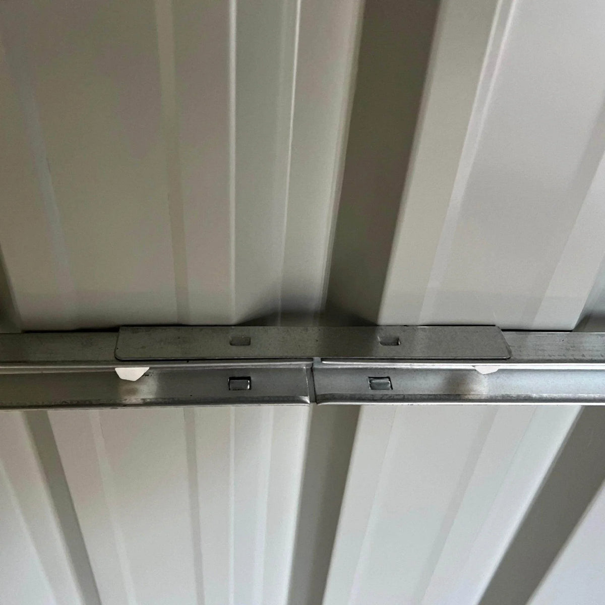 Metal roof support beams and brackets inside the shed