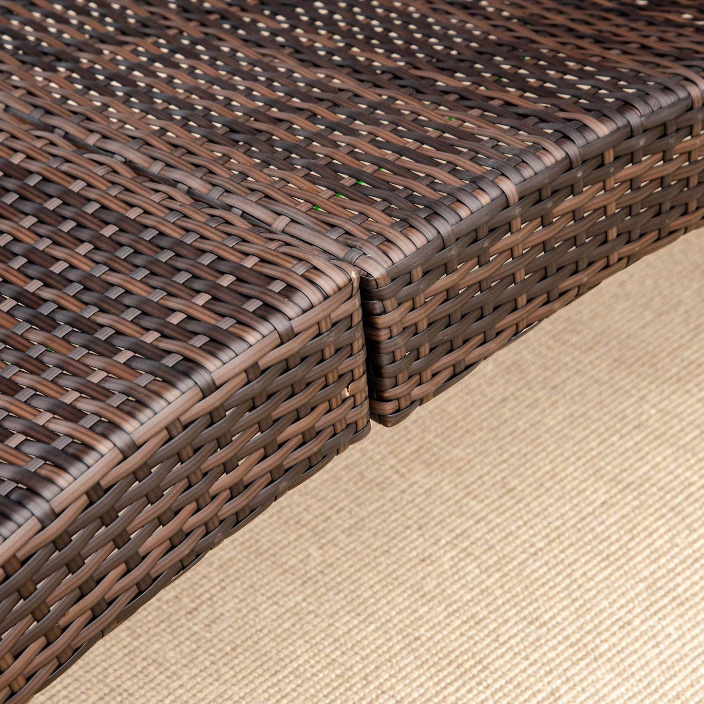 Close-up of mixed brown and white rattan folding sun lounger on beige outdoor rug