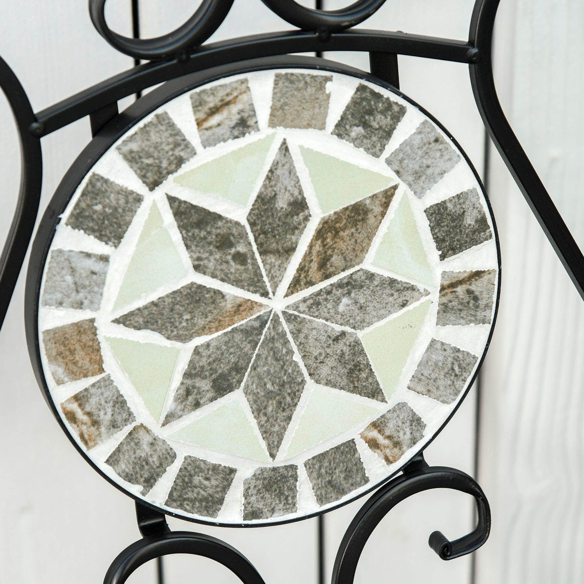 Close-up of round mosaic tile tabletop with gray, beige, and white stone pattern