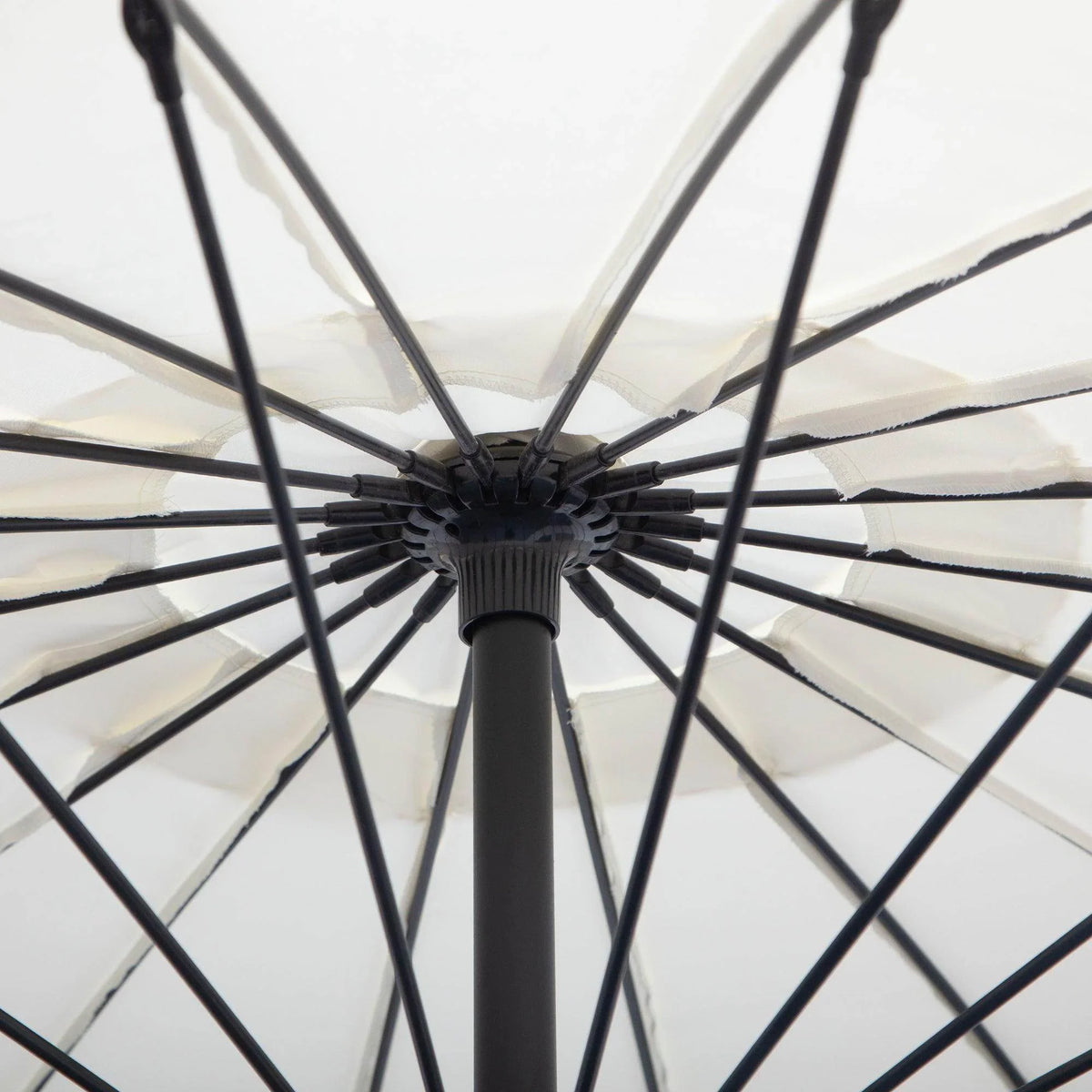 Off-white cantilever parasol underside with black support ribs and central hub