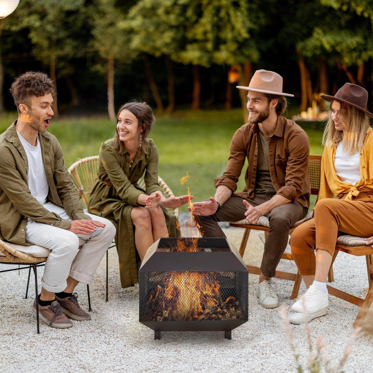 Outdoor fire pit with mesh sides, open top and lid, with poker tool in use