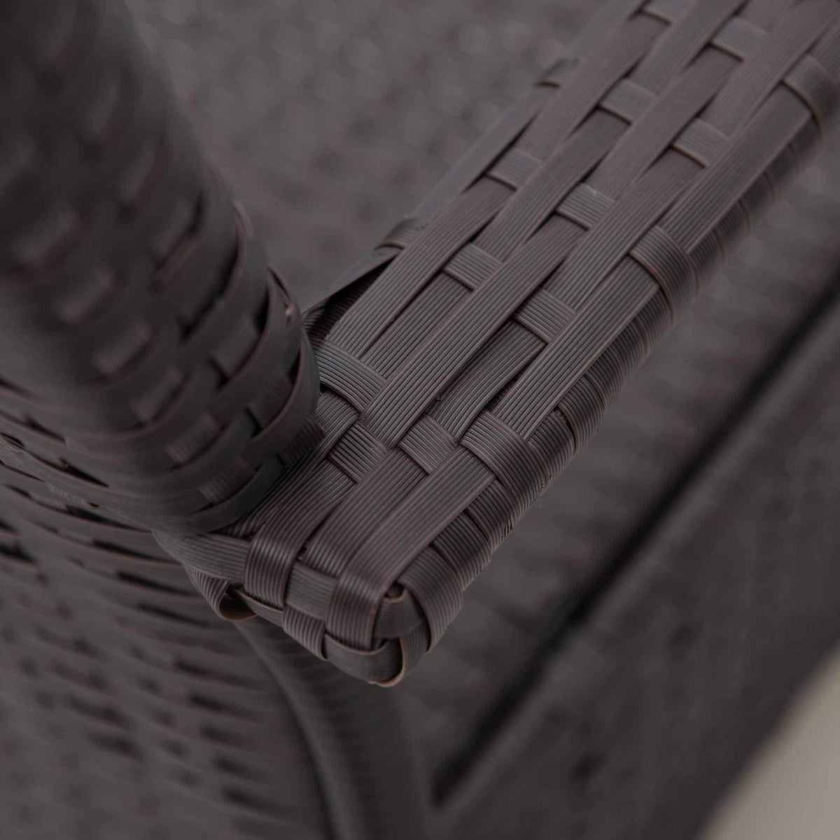 Close-up of dark brown PE wicker weave on outdoor chair frame