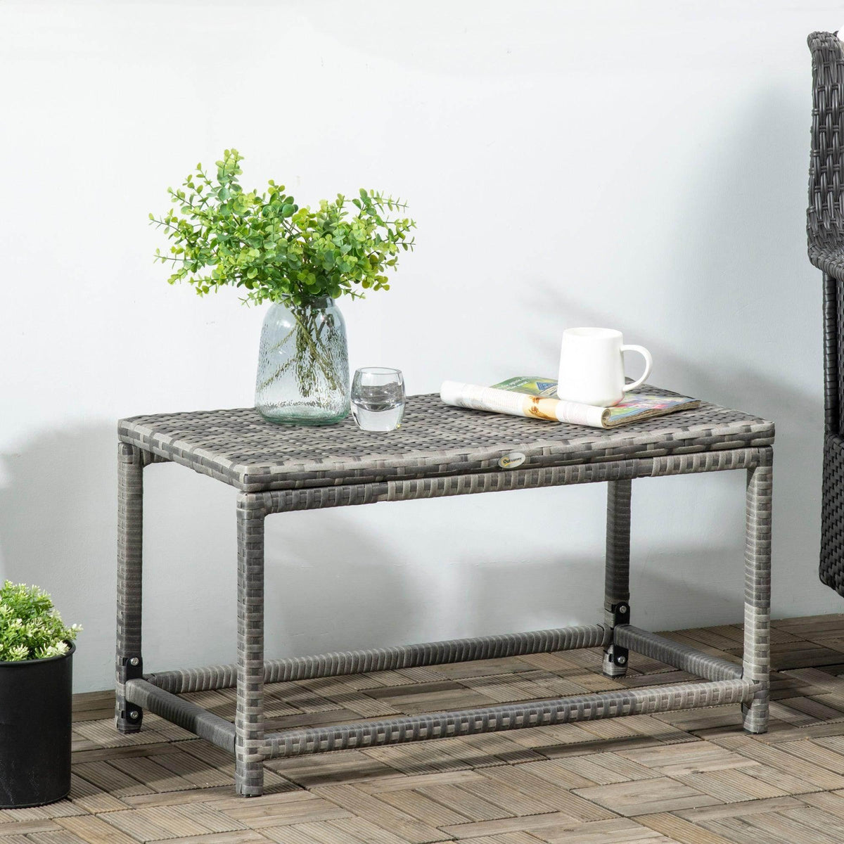 Grey woven rattan outdoor coffee table with open shelf and X-frame support