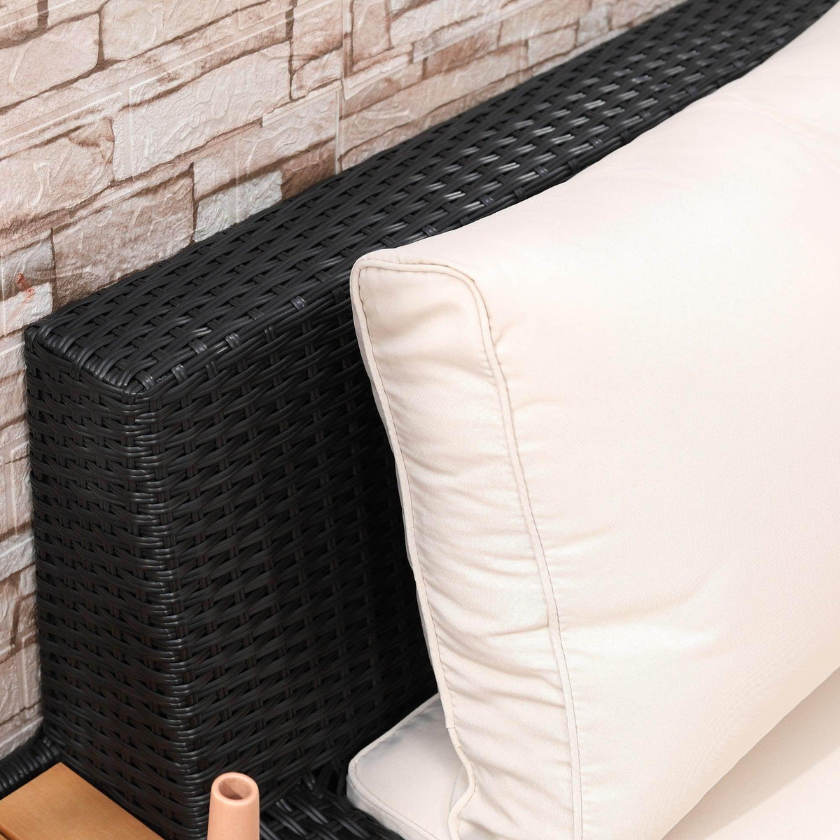 Black woven rattan corner sofa armrest with cream cushion and small side table