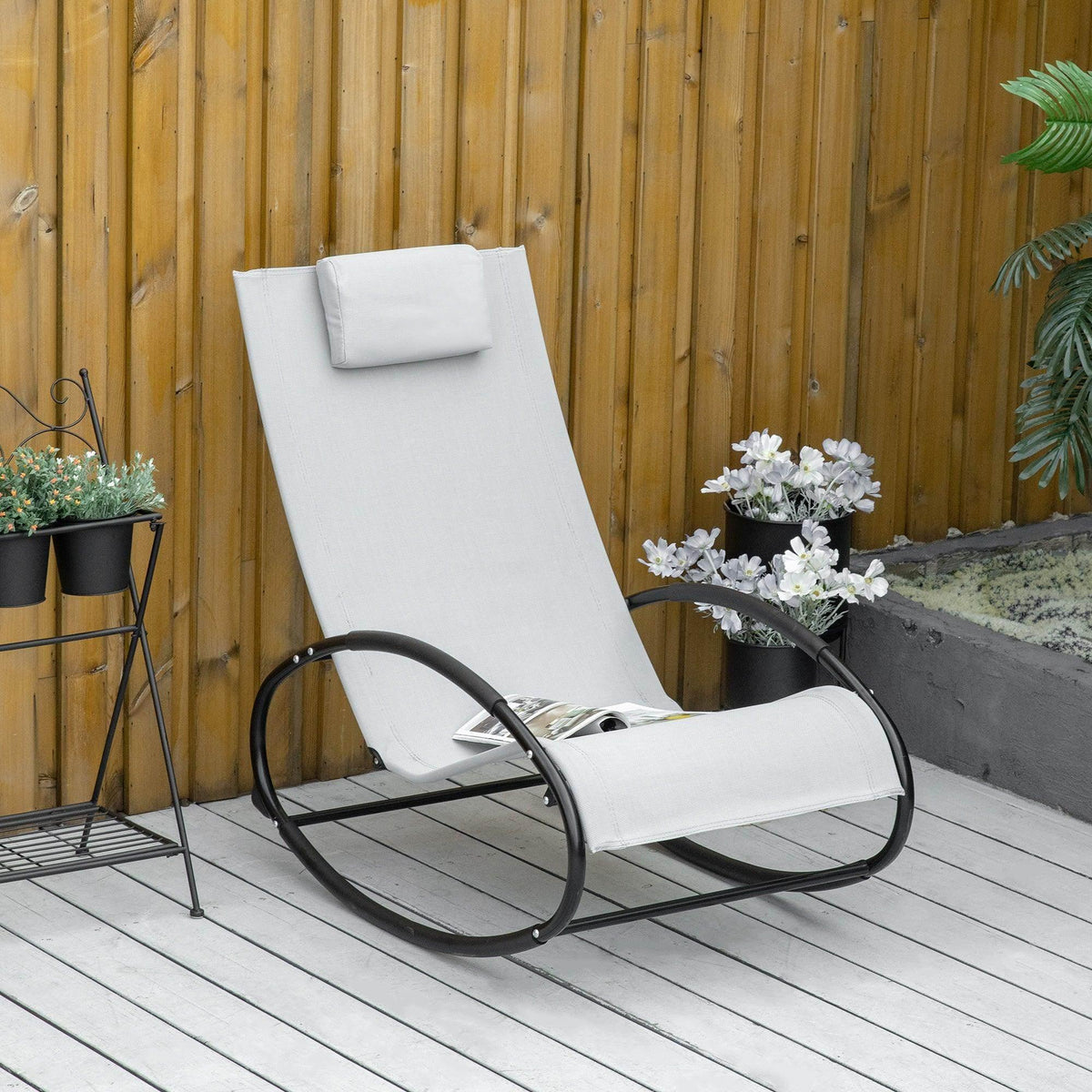 Grey patio rocking lounge chair with headrest pillow and black metal frame