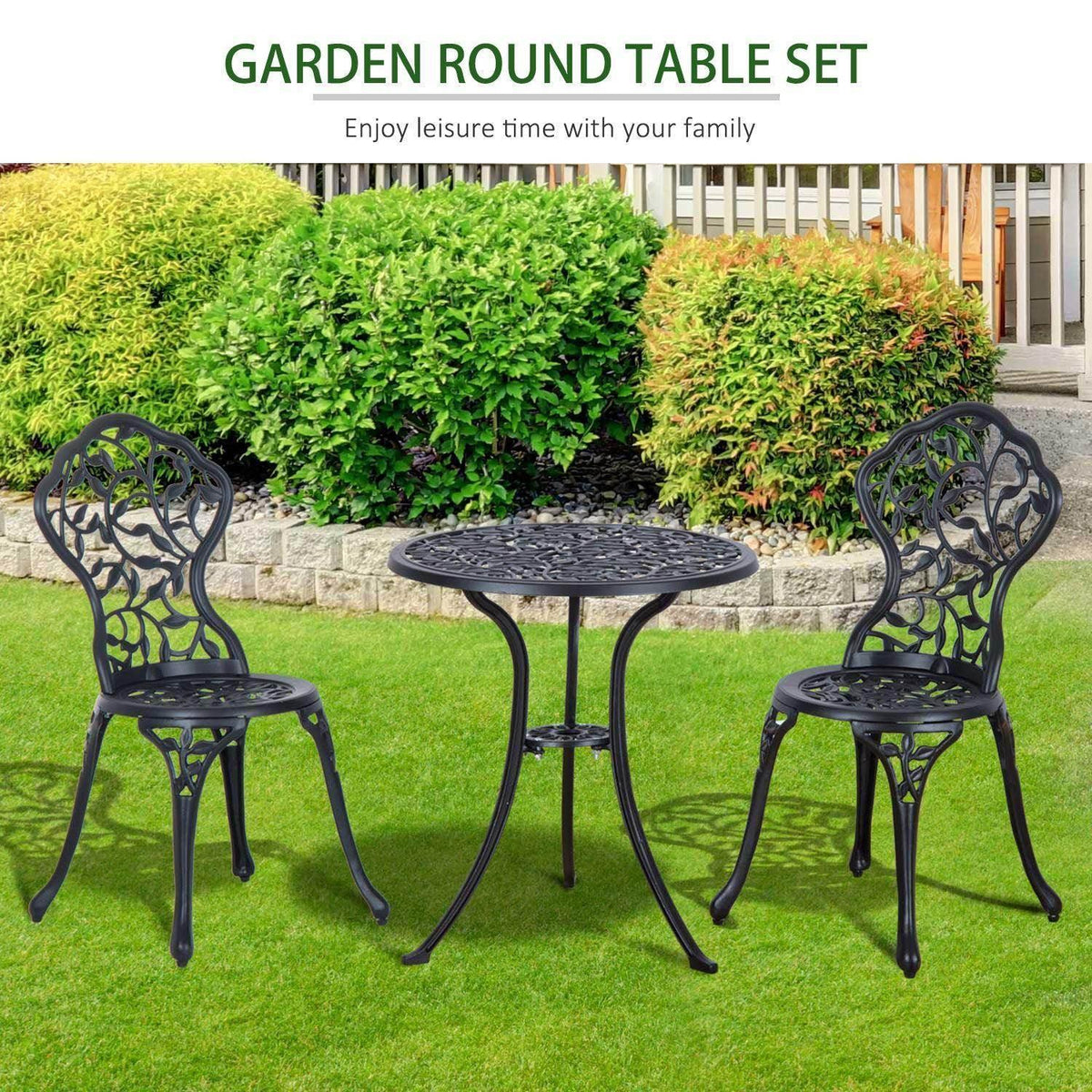 Outdoor round bistro table with two matching chairs, ornate openwork backs on a lawn setting