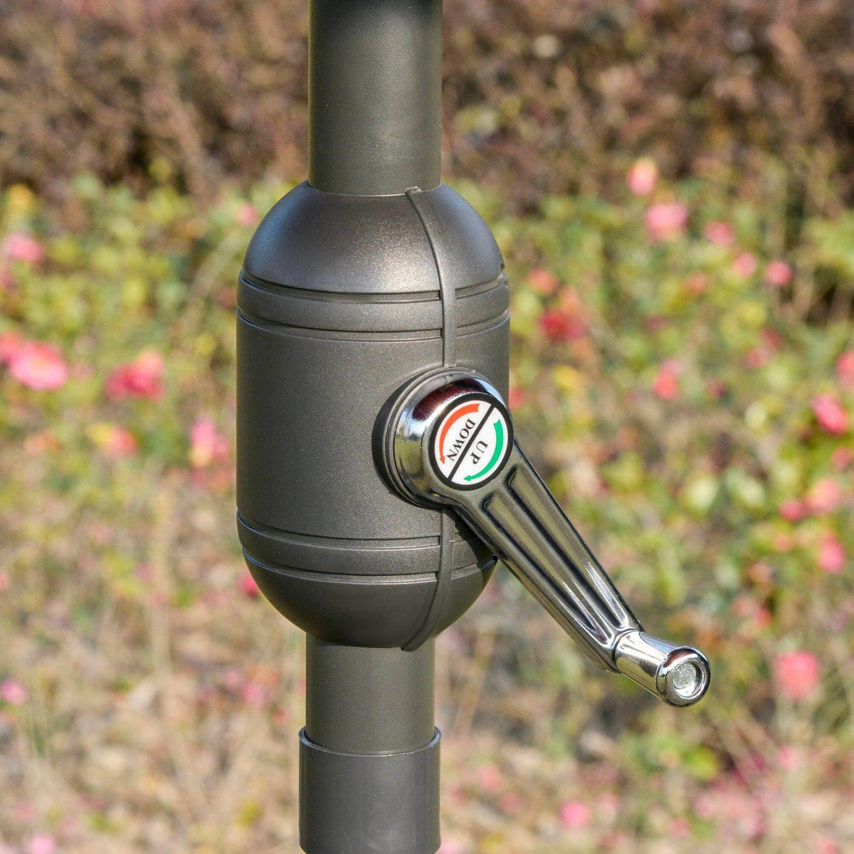 Umbrella manual crank handle on gray pole with chrome accents