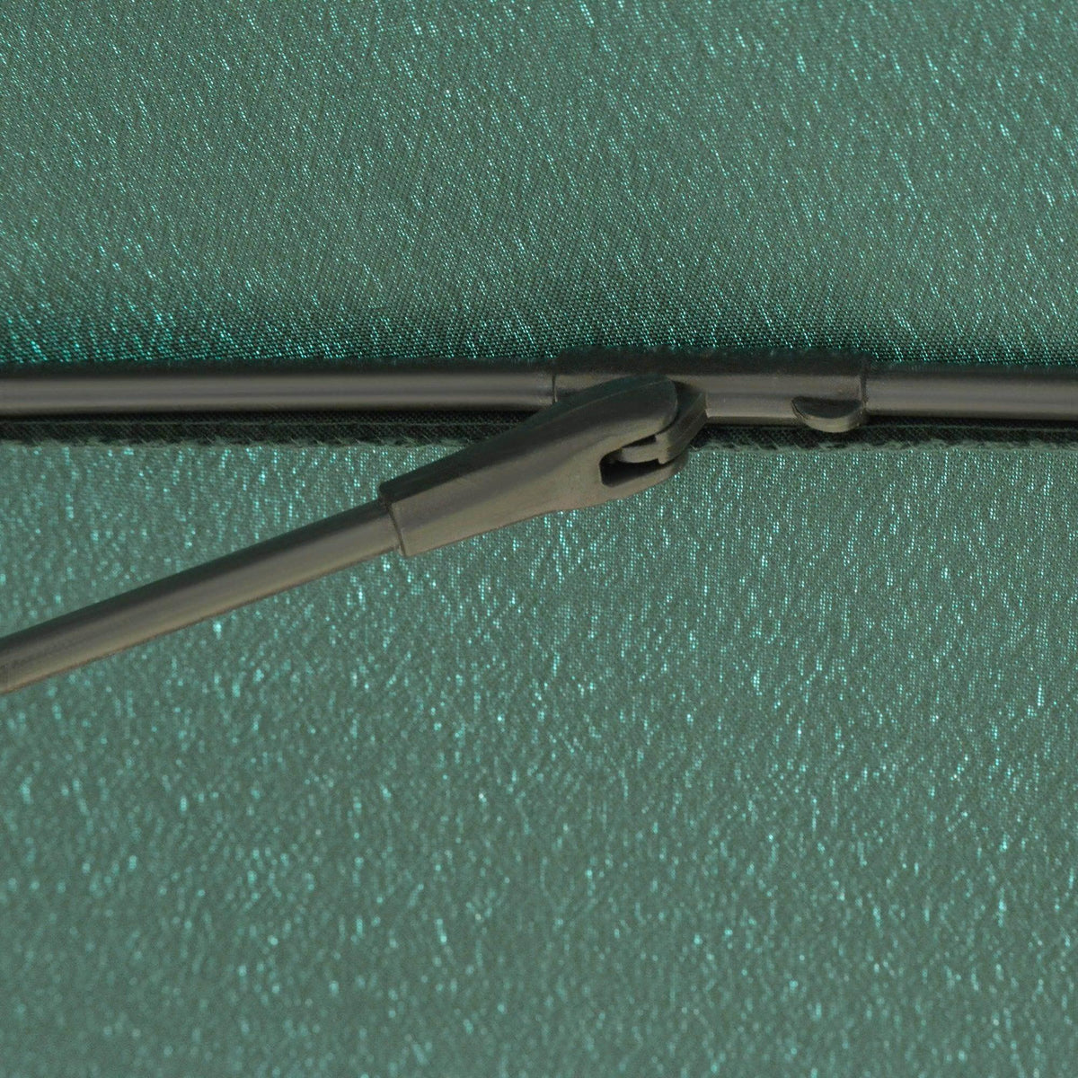 Green umbrella canopy edge with supporting frame arms and fabric texture close-up
