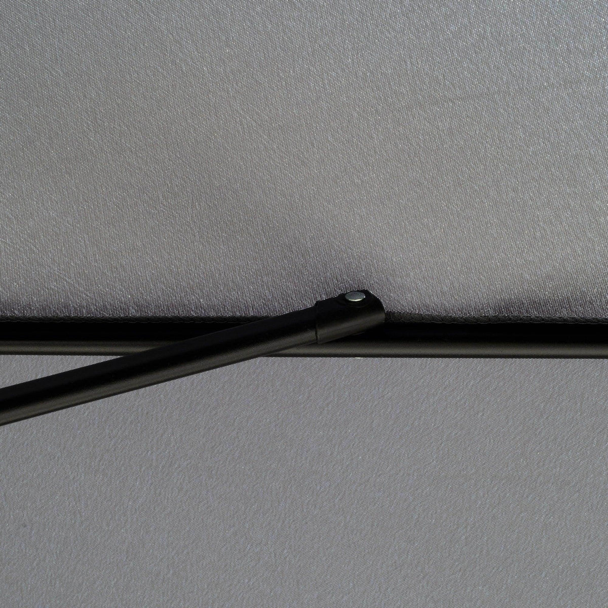 Umbrella canopy fabric secured along a black pole with a clamp fastener