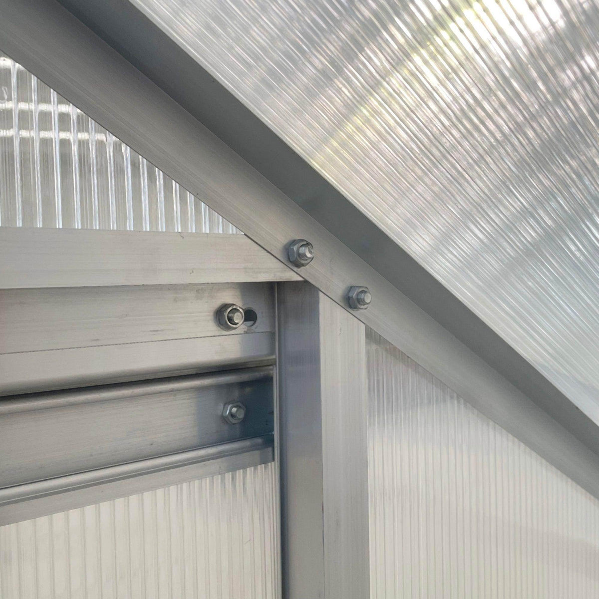 Lean-to greenhouse roof beam corner with clear panels and metal mounting brackets