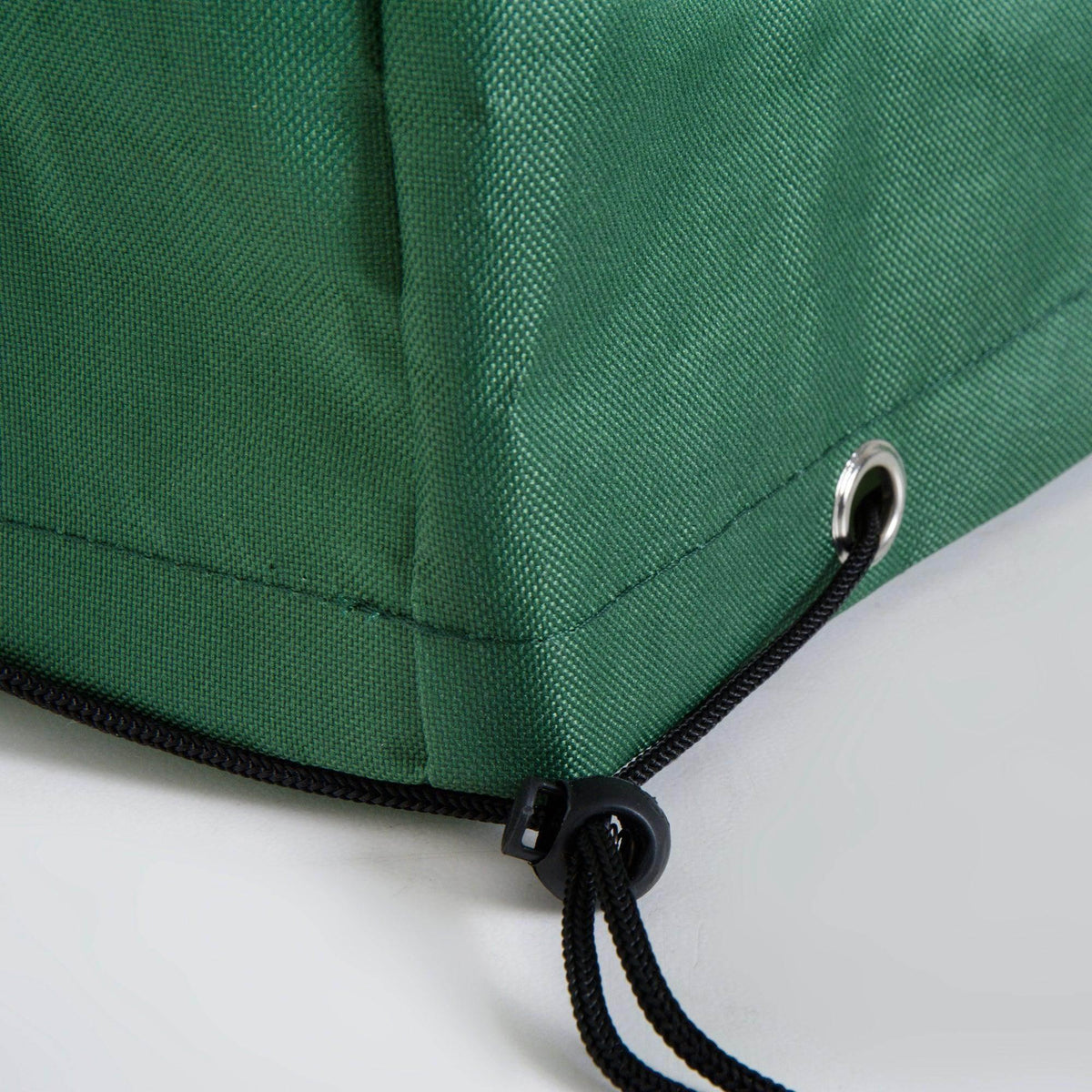 Green outdoor cover with black drawstring and metal grommet for garden furniture protection