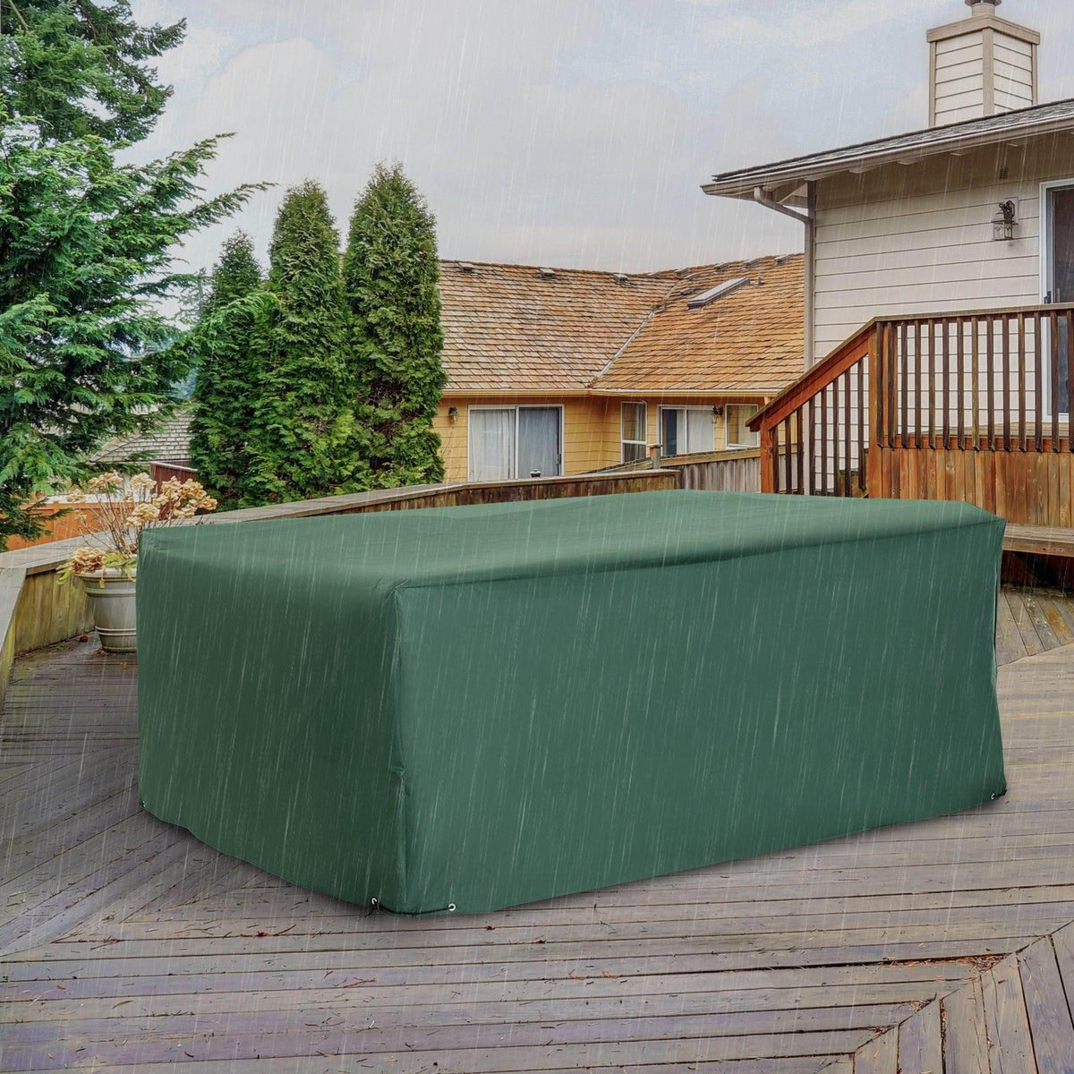 Green waterproof patio furniture cover protecting outdoor table on wooden deck in rain