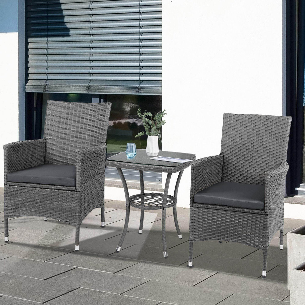 Gray rattan patio bistro set with two cushioned armchairs and a small square glass table