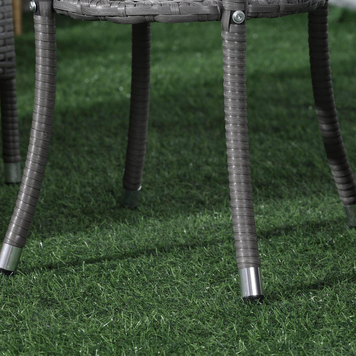Gray rattan bistro set legs with metal supports and woven frame detail