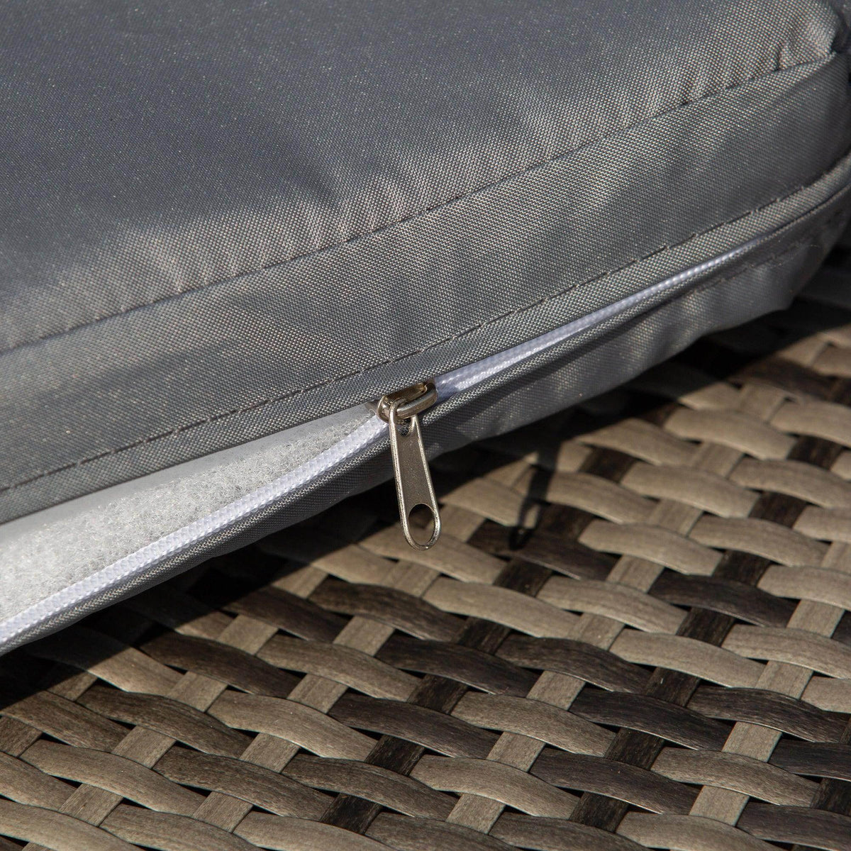 Grey cushion with metal zipper on rattan patio sofa daybed
