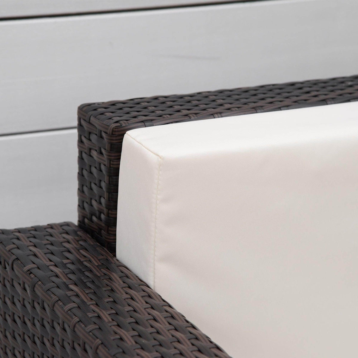 Brown wicker outdoor sofa with cream cushion, ideal for garden or patio seating