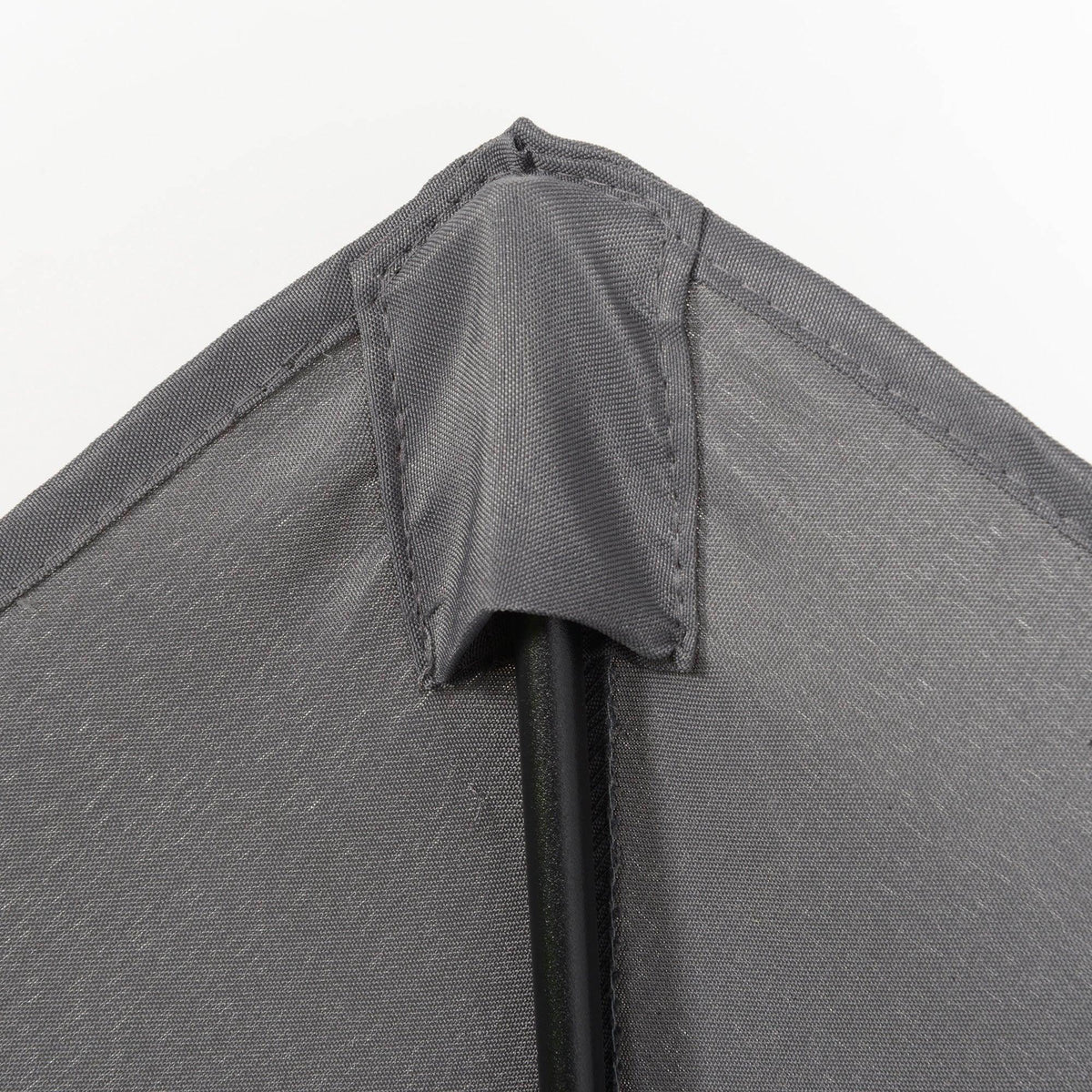Gray patio umbrella canopy fabric close-up with stitched vented underside