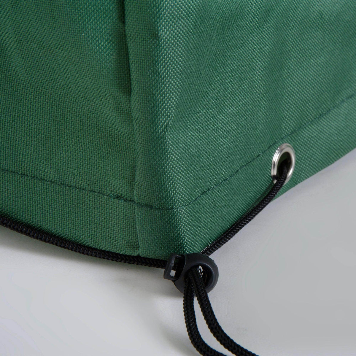 Green outdoor furniture cover with black drawstring and metal grommet for secure fit